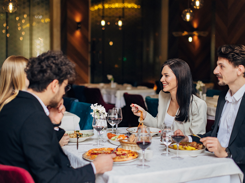 A small group of entrepreneurs having fun during a business lunch in a restaurant